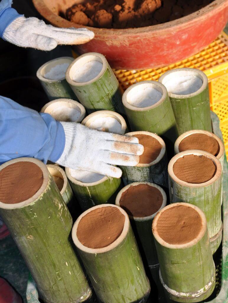 De bamboekokers gevulde met zeezout worden afgesloten met rode bergklei.