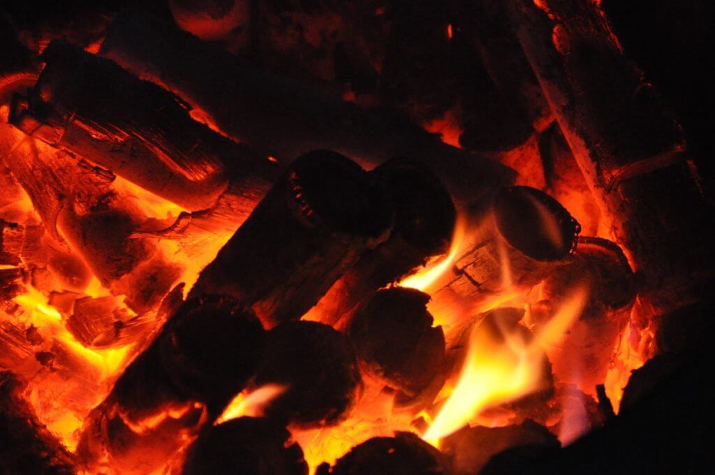 Las cañas de bambú, rellenas de sal marina, se queman en un fuego de madera de pino.